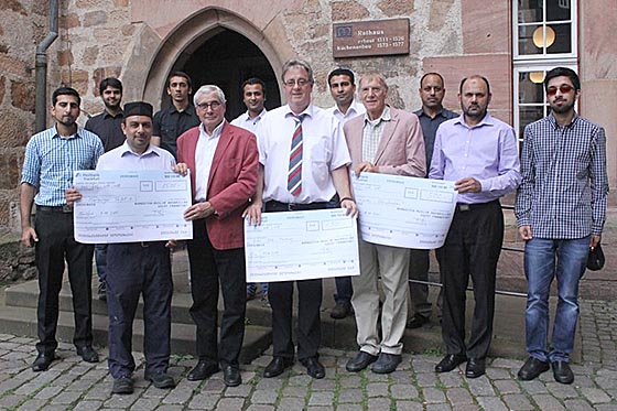 Oberbürgermeister Egon Vaupel (Mitte), Klaus Schellenberg (links daneben) und Erich Geldbach (rechts daneben) freuten sich über die symbolischen Schecks, die Saadat Ahmed, links Asif Farhad, Rafique Khawaja, Umär Ilyas, Asad Rafiq, Nadeem Ahmed, Fazalollah Khan, Muhammad Ilyas und Kamran Khan überbrachten. Foto Heiko Krause